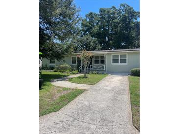 Charming single-story home with a concrete driveway, lush landscaping, and a welcoming front porch at 275 Virginia Dr, Winter Garden, FL 34787