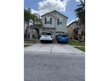 Two-story home featuring a two-car garage, neutral color palette, and a spacious driveway at 2753 Monticello Way, Kissimmee, FL 34741