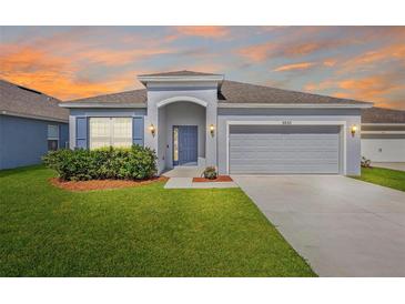 Charming single-story home with a well-maintained lawn, a two-car garage and a welcoming front entrance at 3532 Yarian Dr, Haines City, FL 33844