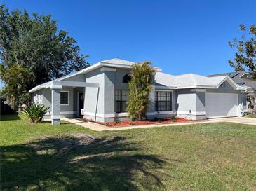 Charming single-story home featuring a well-manicured lawn and attached two car garage at 377 Blue Bayou Dr, Kissimmee, FL 34743