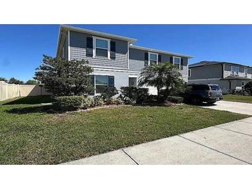 Charming two-story home with blue siding, manicured lawn, and a paved driveway at 439 Sunfish Dr, Winter Haven, FL 33881