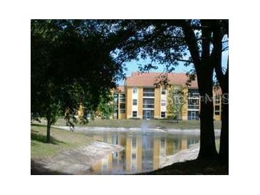 Inviting condo community featuring serene lake view and lush landscaping, creating a tranquil residential setting at 5279 Images Cir # 301, Kissimmee, FL 34746