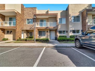 Inviting townhouse featuring a private balcony and well-maintained landscaping at 7645 Recife Dr, Kissimmee, FL 34747