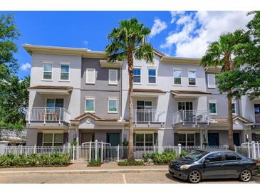 Charming multi-story townhome with a well-manicured lawn and a classic white picket fence at 810 Greybull Run, Lake Mary, FL 32746