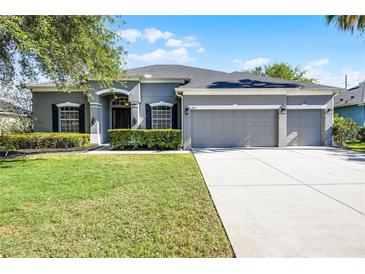 Charming single-Gathering home showcasing a well-manicured lawn, grey trim, and a convenient three-car garage at 849 Shadowmoss Dr, Winter Garden, FL 34787