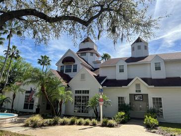 Beautiful two-story white condo building with palm trees and manicured landscaping against a blue sky at 11574 Westwood Blvd # 1126, Orlando, FL 32821