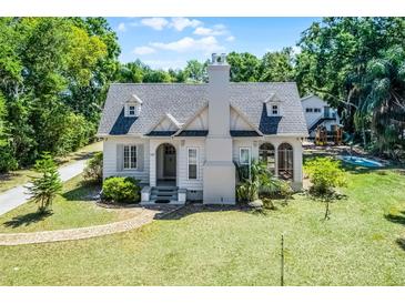 Charming two-story home with lush front yard, brick pathway, and traditional architectural details at 1210 S Clayton St, Mount Dora, FL 32757