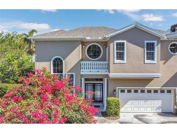Charming two-story home featuring a two-car garage and an inviting front entrance with lush landscaping at 1251 Arlington Pl, Winter Park, FL 32789