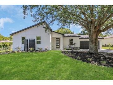 Inviting home exterior featuring a manicured lawn, modern design, and dark accents at 1365 Lake Dr, Casselberry, FL 32707
