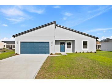 Beautiful single-Gathering home with modern architecture, a well-manicured lawn, and blue garage door at 14953 Sw 38Th Cir, Ocala, FL 34473