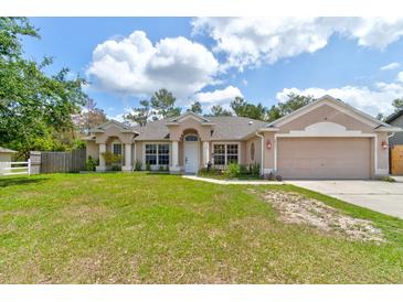Charming single-story home featuring a well-manicured lawn and a two-car garage at 2951 E Waco Dr, Deltona, FL 32738