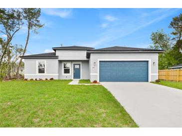 Charming single-Gathering home with a well-manicured lawn, blue accents, and a two-car garage at 443 Marion Oaks Crse, Ocala, FL 34473