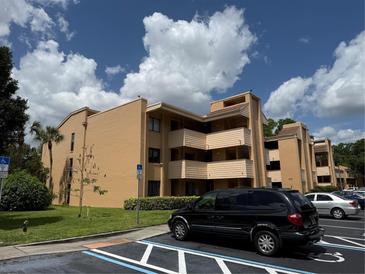 Tan two-story condo with balconies and well-maintained landscaping near marked parking spot at 510 Cranes Way # 105, Altamonte Springs, FL 32701