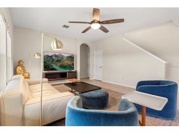 Bright living room with neutral tones, modern furniture, ceiling fan, and a stylish floor lamp at 660 Egret Place Dr, Winter Garden, FL 34787