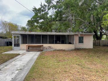 Modest single story home with screened-in porch, concrete drive and mature trees at 11625 Churchill St, Orlando, FL 32817