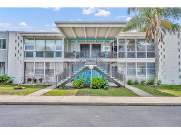 Charming condo with striking blue accents and lush landscaping, offering a welcoming facade and curb appeal at 151 N Orlando Ave # 115, Winter Park, FL 32789