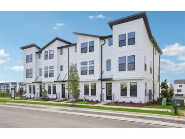 Charming white townhomes feature modern design, black accents, and manicured landscaping in a vibrant community at 15483 Hamlin Park Drive, Winter Garden, FL 34787