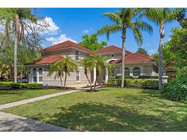 Beautiful two-story home with tile roof, well-manicured lawn, and mature palm trees at 1803 Glenbay Ct, Windermere, FL 34786