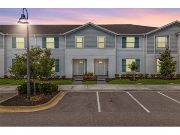 Charming townhome with neat landscaping, gray siding, and blue shutters at 2432 Tangier Dr, Kissimmee, FL 34747