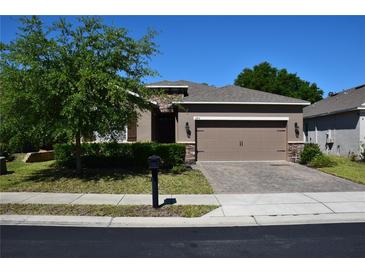 Charming single-story home featuring a well-manicured front yard and a two-car garage at 245 Brunswick Dr, Davenport, FL 33837