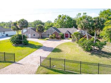 Beautiful exterior home features well-manicured lawn, a red door and palm trees at 2836 S Stewart St, Kissimmee, FL 34746