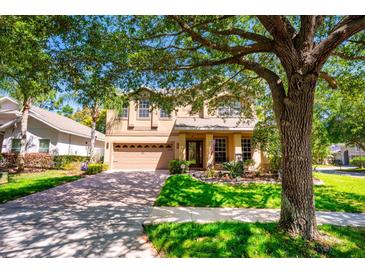 Charming home featuring a well-manicured lawn, mature trees, and a welcoming two-car garage at 310 Stakes Ct, Deland, FL 32724