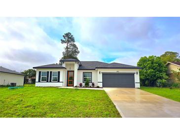 Charming single-story home featuring a gray roof, a gray garage door, and a beautifully landscaped front yard at 492 Marion Oaks Mnr, Ocala, FL 34473