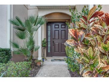 Welcoming front door surrounded by lush landscaping and an arched entryway at 558 Pinebranch Cir, Winter Springs, FL 32708