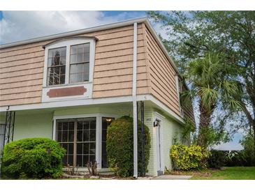 Charming exterior of a townhome featuring classic architecture and lush landscaping around the property at 6021 Village Cir # 6021, Orlando, FL 32822