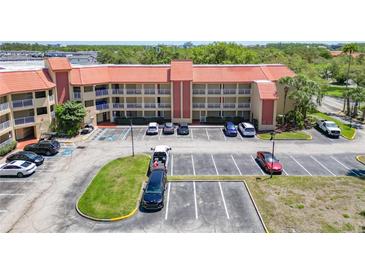 Wide angle shot of the three-story exterior with terracotta tile roof, multiple balconies, and ample parking in front at 6403 Parc Corniche Dr # 4114, Orlando, FL 32821