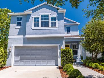 Charming two-story home featuring a gray garage, yellow door, and well-manicured landscaping at 6807 Habitat Dr, St Cloud, FL 34773