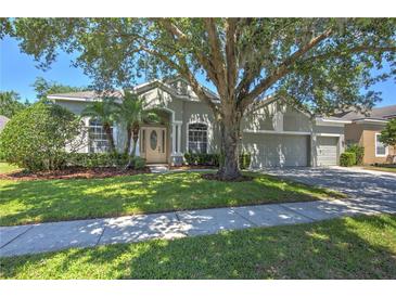 Charming single-story home featuring lush landscaping and a spacious three-car garage at 7167 Winding Lake Cir, Oviedo, FL 32765