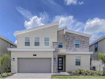 Beautiful two-story home boasts stone accents and a two-car garage at 8844 Cabot Cliffs Dr, Davenport, FL 33896