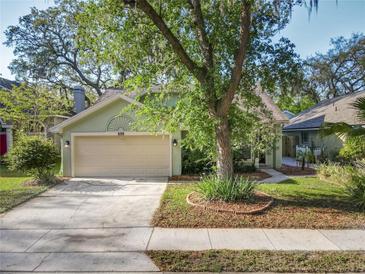 Charming single-story home with a well-manicured lawn, mature trees, and a beige two-car garage at 998 Piedmont Oaks Dr, Apopka, FL 32703