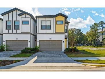 Modern townhome showcasing a two-car garage, neutral paint, and a meticulously designed exterior at 10436 Ebb Tide Lane, Orlando, FL 32821