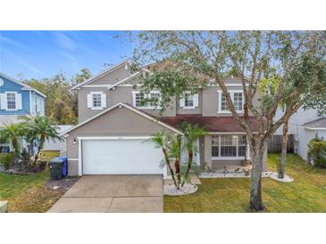 Charming two-story home with a well-maintained lawn, a two-car garage, and lush landscaping at 1176 Liberty Hall Dr, Kissimmee, FL 34746