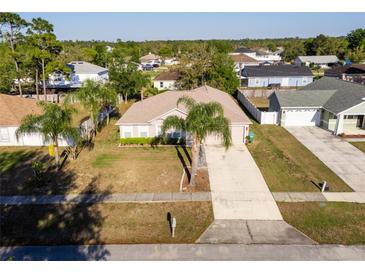 Charming single-story home with lush landscaping, a long driveway, and a two-car garage at 1632 Lansfield Ave, Deltona, FL 32738