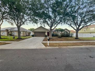 Charming single-story home with mature trees, a well-manicured lawn, and a two-car garage at 1730 Lochshyre Loop, Ocoee, FL 34761