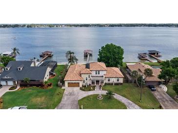 Stunning lakefront home with private dock, lush lawn, and beautiful landscaping at 2501 Trentwood Blvd, Belle Isle, FL 32812