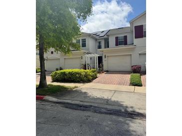Well-maintained townhouses boast brick driveways, attached garages and manicured landscaping at 3181 Capri Isle Way, Orlando, FL 32835