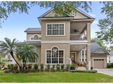 Stunning two-story home featuring a charming front porch and manicured lawn at 6037 Caymus Loop, Windermere, FL 34786