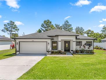 Beautiful single Gathering home featuring a manicured lawn, two car garage and freshly painted exterior at 675 S Cedar Ave, Orange City, FL 32763