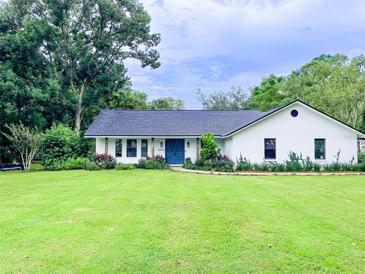 Charming one-story home with a well-manicured lawn and colorful landscaping at 29540 Deerwood Farms Rd, Sorrento, FL 32776