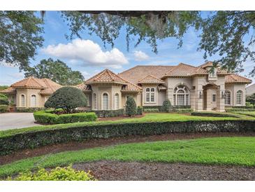 Stunning home exterior displays manicured landscaping, decorative shrubs, and a tiled roof at 13025 Water Point Blvd, Windermere, FL 34786