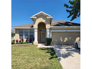 Charming single-Gathering home featuring a well-manicured lawn and attached two-car garage at 2445 Cypress Trace Cir, Orlando, FL 32825