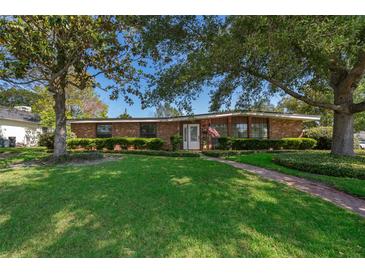 Charming brick home featuring a lush green lawn, mature trees, and a welcoming front entrance at 2609 Chinook Trl, Maitland, FL 32751