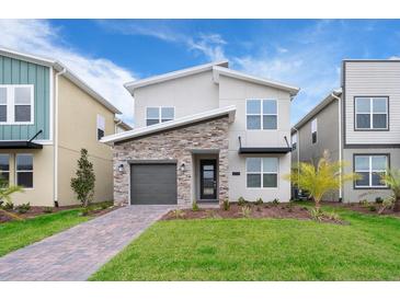 Charming two-story home with stone accents, landscaped yard, and modern design at 2771 Oxymoron Way, Kissimmee, FL 34746