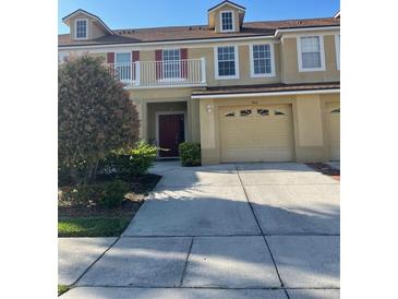 Charming townhouse featuring a balcony, two-car garage, and well-maintained landscaping at 3111 Wentworth Ln, Kissimmee, FL 34741
