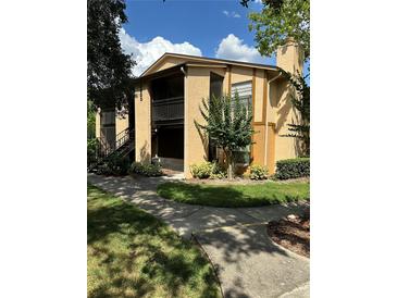 Exterior shot of a well-maintained condo, showcasing its architecture and verdant surroundings at 4800 S Semoran Blvd # 101, Orlando, FL 32822