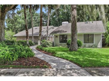 Charming single-story home featuring lush landscaping, a stone facade, and a welcoming walkway at 700 Bear Shadow Ct, Longwood, FL 32779